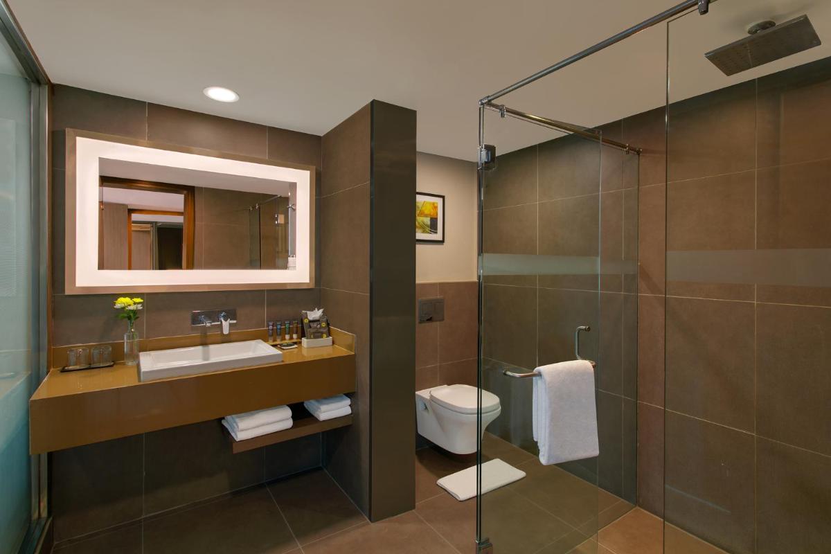 a bathroom with a toilet and a sink and a shower at Novotel Ahmedabad in Ahmedabad
