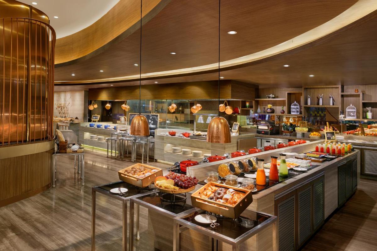 a buffet in a restaurant with food on display at Novotel Ahmedabad in Ahmedabad