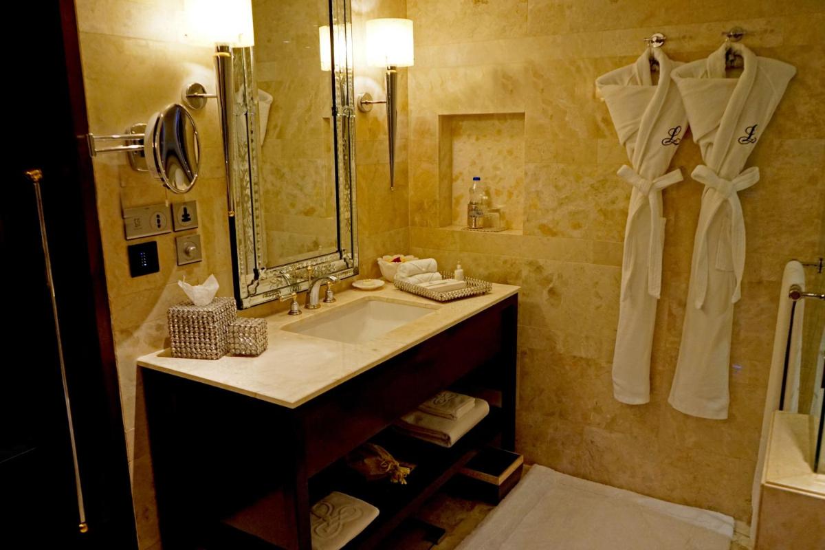 a bathroom with a sink and a large mirror at The Leela Palace Udaipur in Udaipur