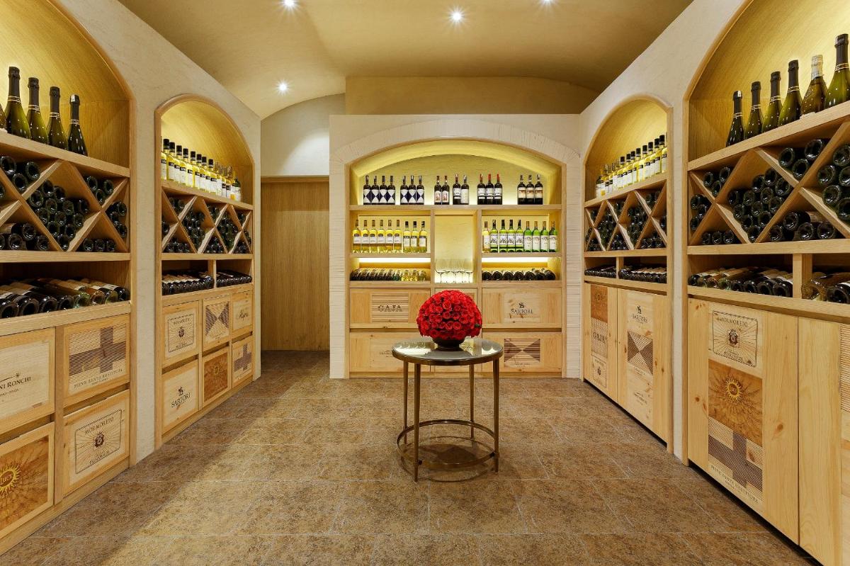 a wine cellar with a table and wine bottles at The Lodhi – A member of The Leading Hotels Of The World in New Delhi