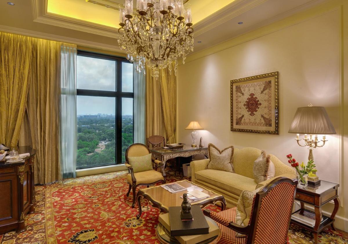a living room with a chandelier and a large window at The Leela Palace New Delhi in New Delhi a living room with a chandelier and a large window at The Leela Palace New Delhi in New Delhi