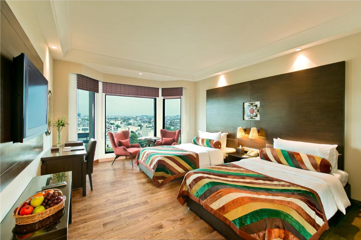 a hotel room with two beds and a desk and a room at The Lalit Jaipur in Jaipur +44 photos