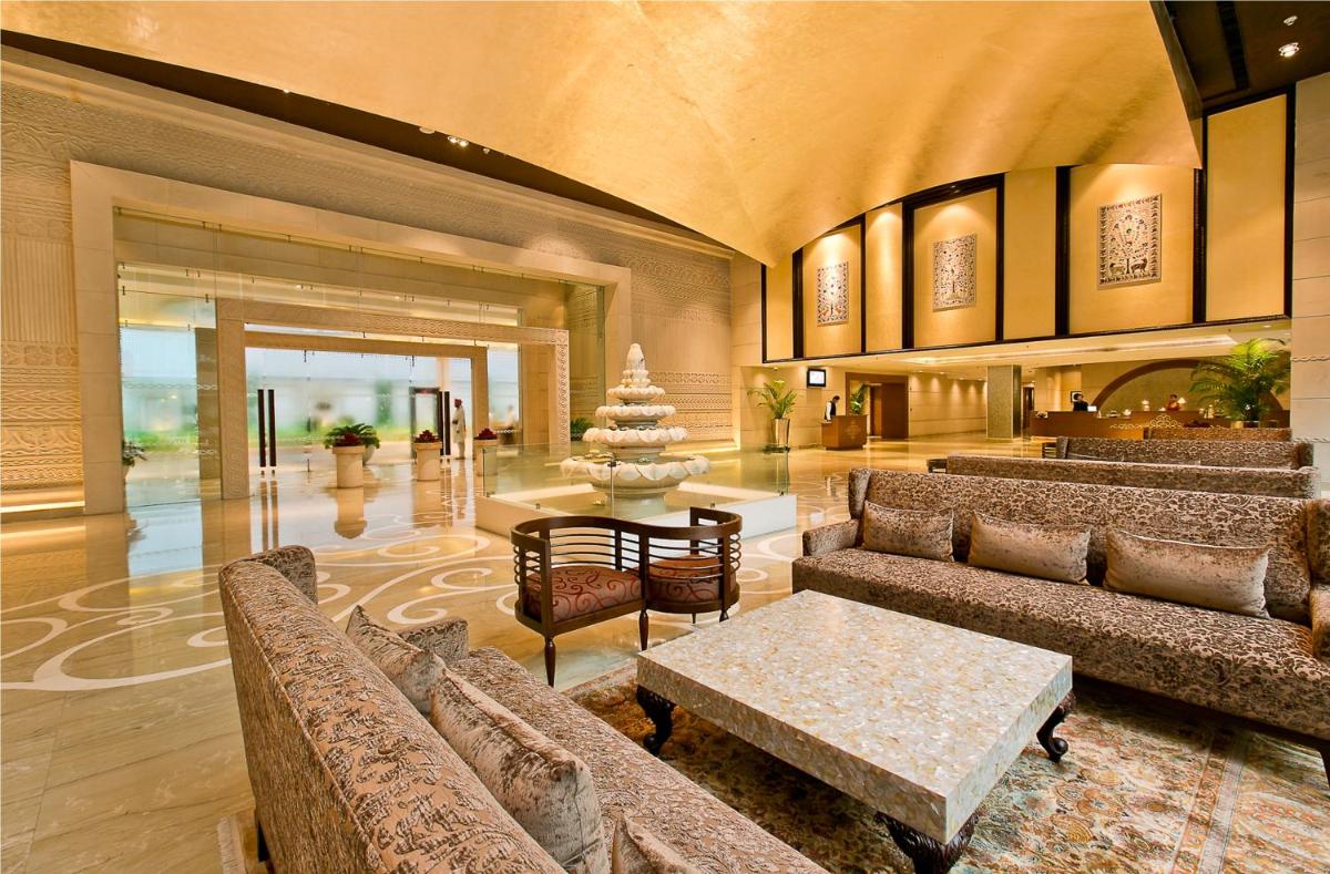 a lobby with couches and a table in a building at The Lalit Jaipur in Jaipur