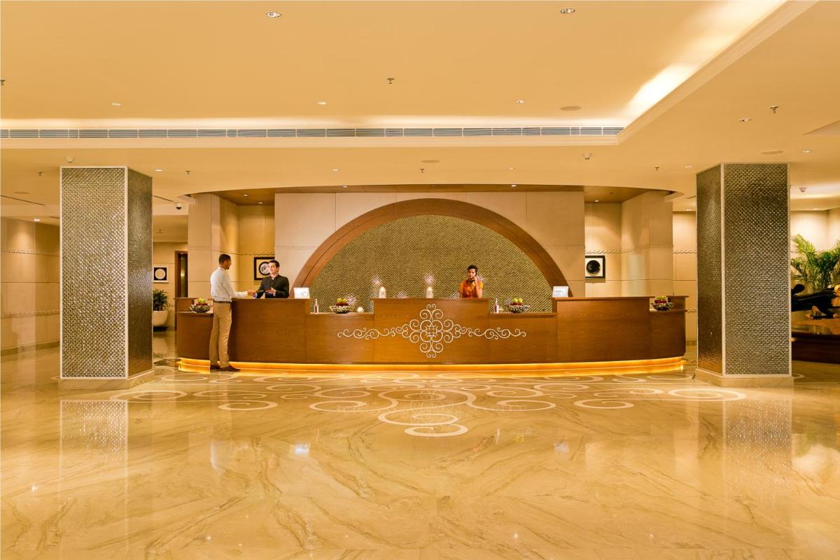 a lobby with a reception desk in a hotel at The Lalit Jaipur in Jaipur