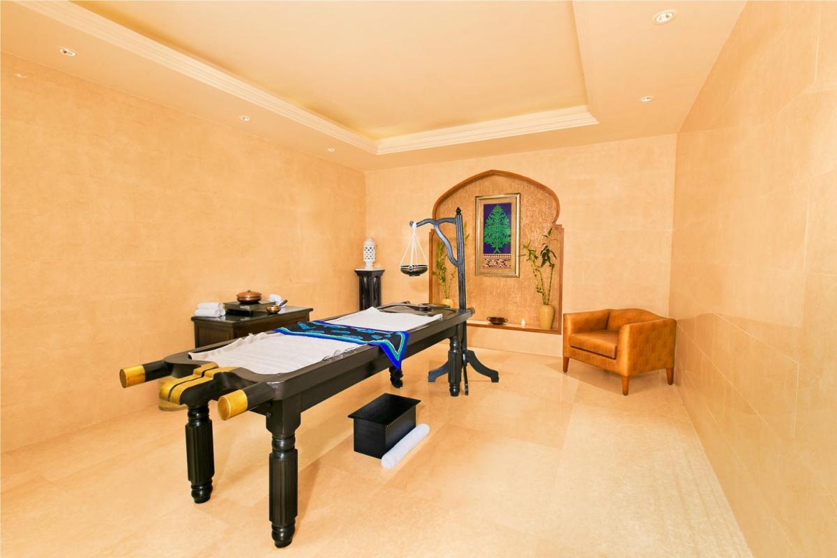 a hospital room with a bed and a chair at The Lalit Jaipur in Jaipur