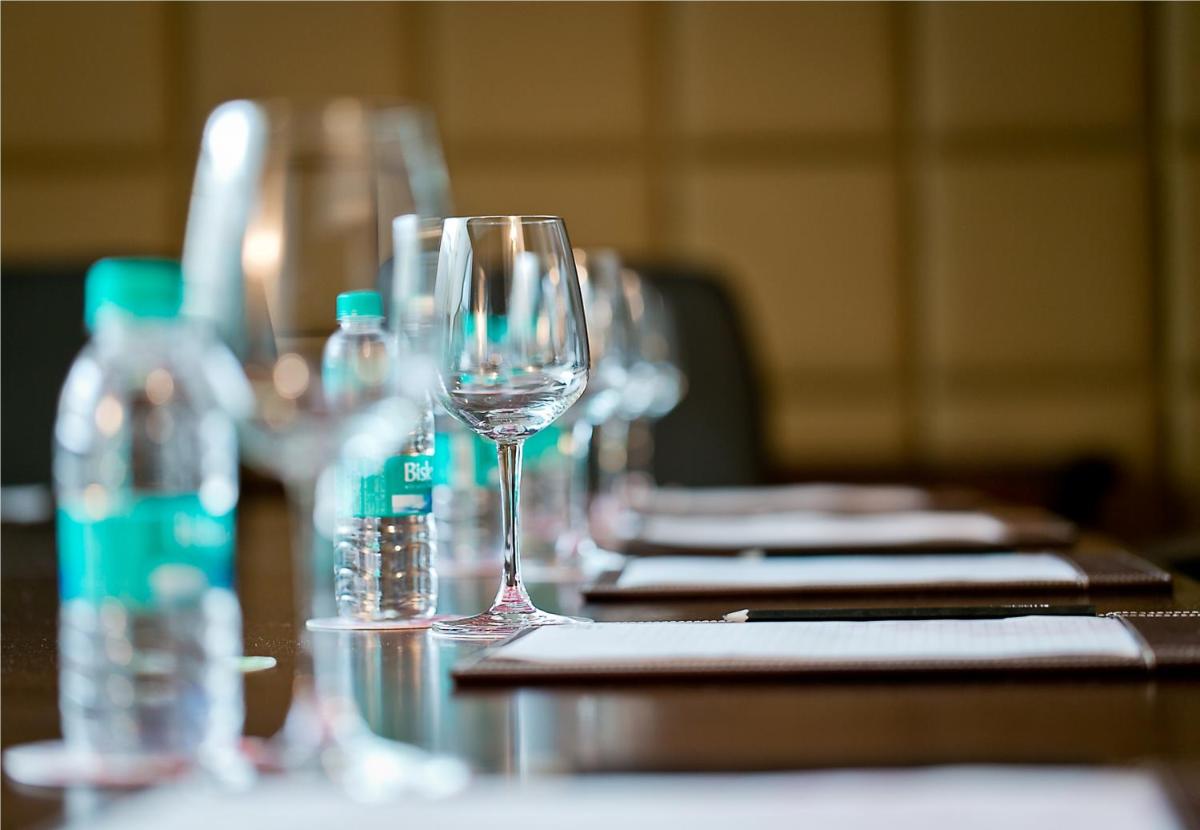 a row of wine glasses sitting on a table with water bottles at The Lalit Jaipur in Jaipur