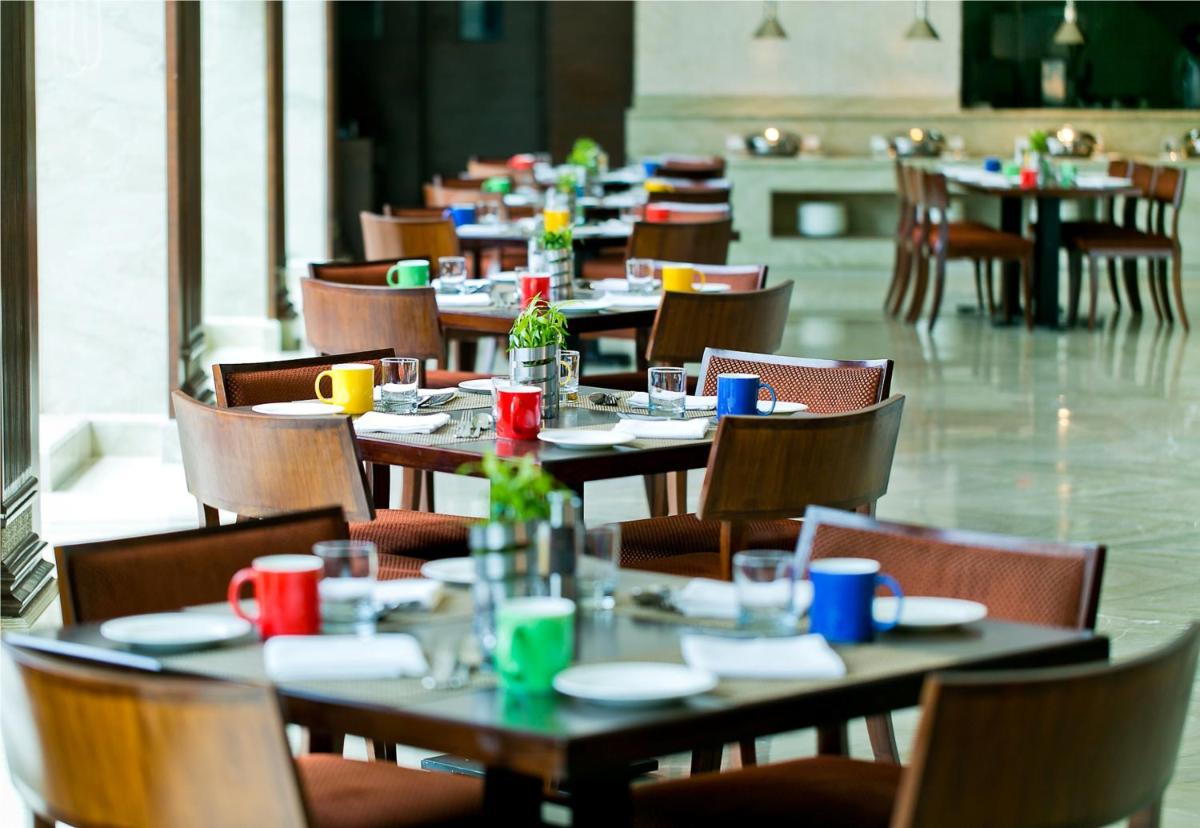 a row of tables and chairs in a restaurant at The Lalit Jaipur in Jaipur