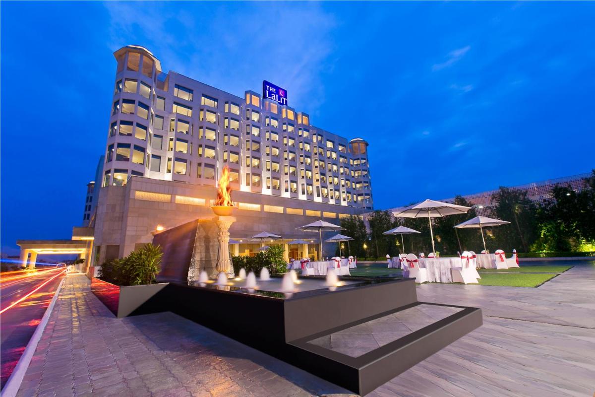 a hotel with a fountain in front of a building at The Lalit Jaipur in Jaipur