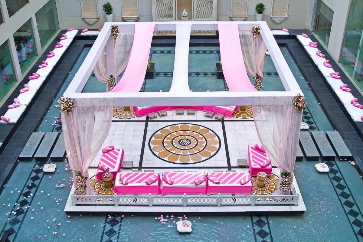 a pool with a pink couch in the middle at The Lalit Jaipur in Jaipur