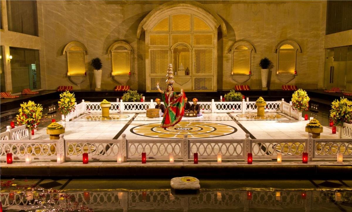 a room with a fountain in the middle of a building at The Lalit Jaipur in Jaipur