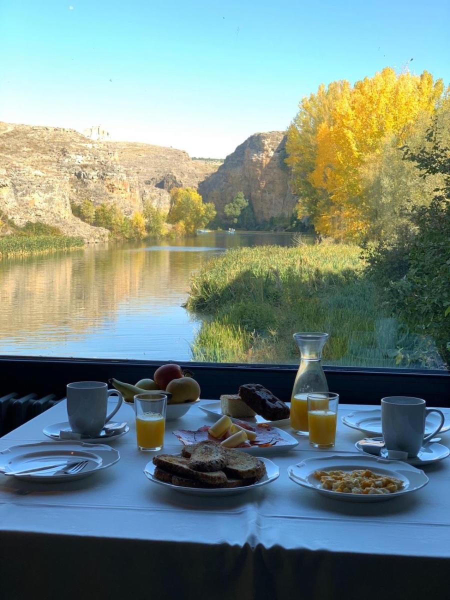 una mesa con comida y vistas al río en Molino Grande del Duratón, en San Miguel de Bernúy