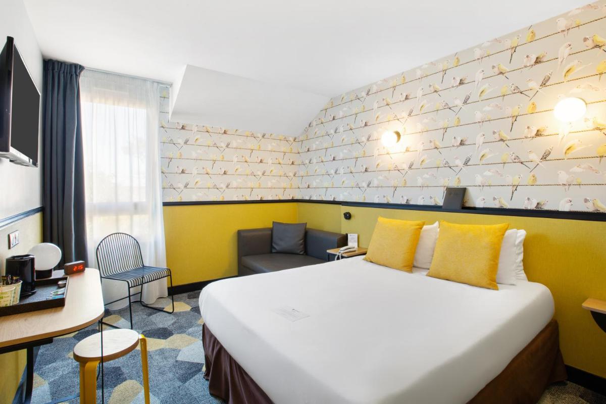 une chambre d'hôtel avec un lit et un canapé dans l'établissement Best Western Hôtel Grand Parc Marne La Vallée, à Chanteloup-en-Brie
