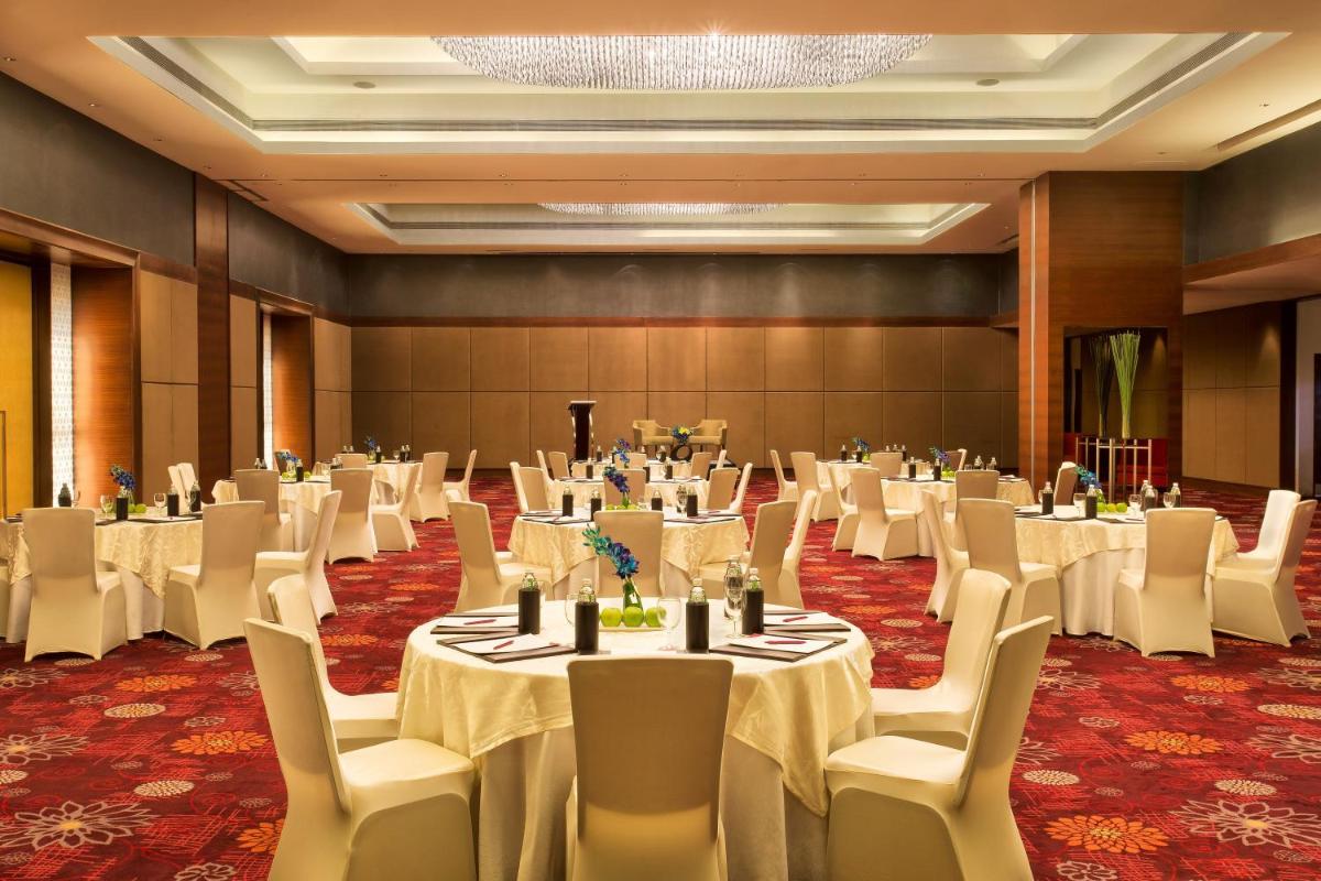 a banquet hall with white tables and chairs at Crowne Plaza Ahmedabad City Centre by IHG in Ahmedabad