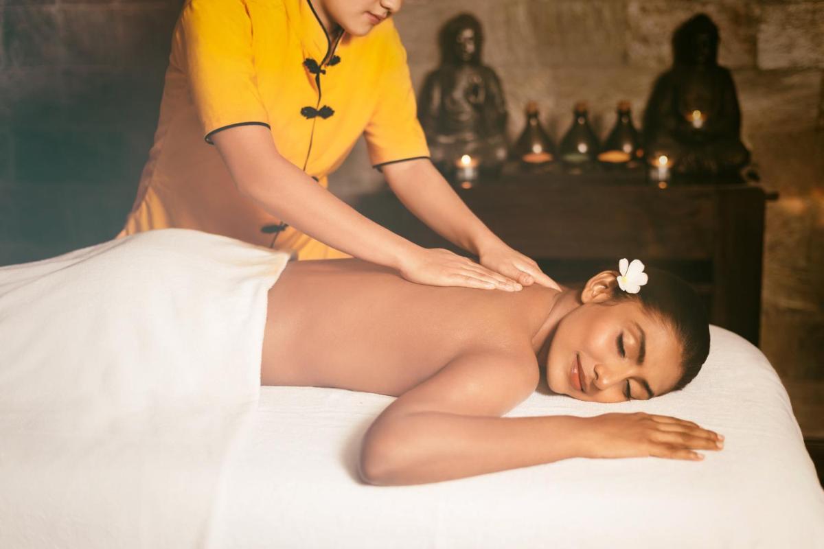 a woman getting her hair washed by a massage therapist at Crowne Plaza Ahmedabad City Centre by IHG in Ahmedabad