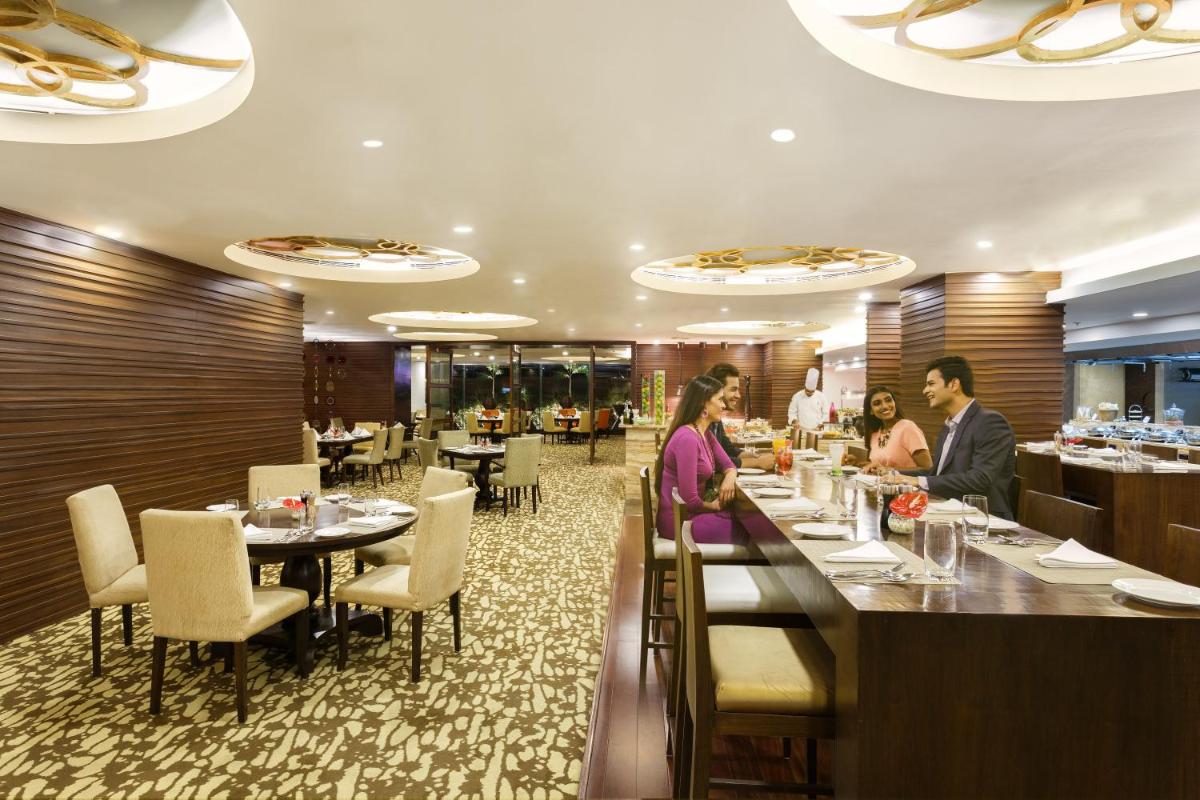 a restaurant with people sitting at a bar at Crowne Plaza Ahmedabad City Centre by IHG in Ahmedabad
