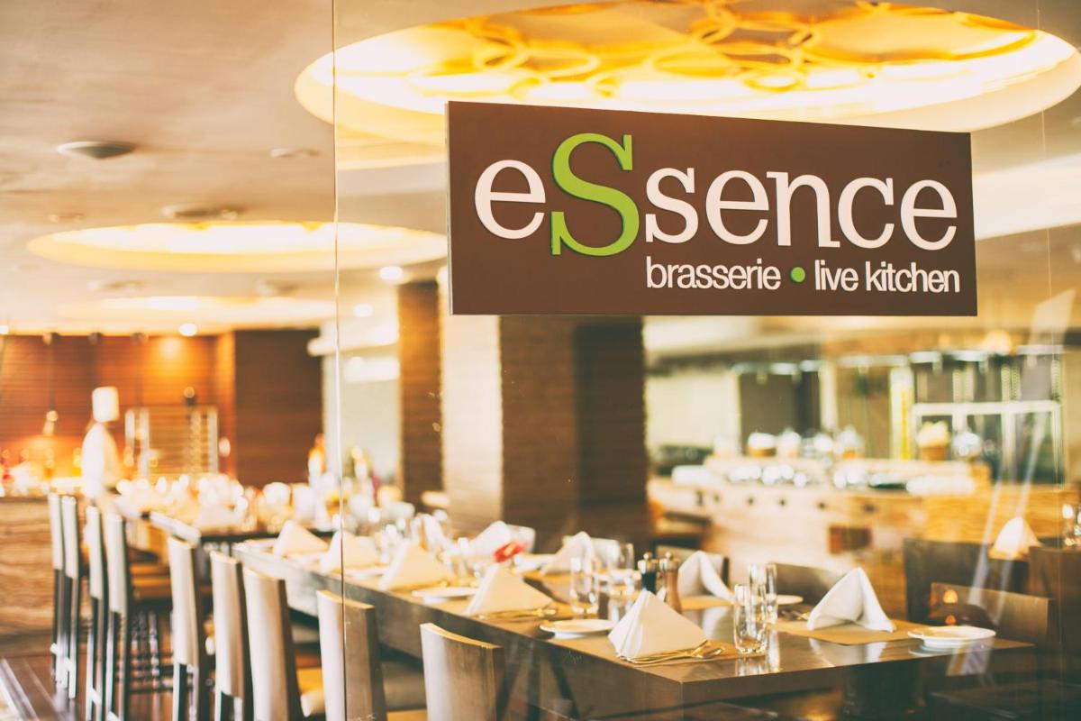 a row of tables in a restaurant with a sign at Crowne Plaza Ahmedabad City Centre by IHG in Ahmedabad