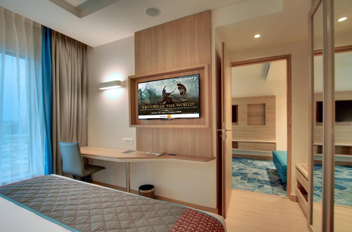 a hotel room with a bed and a desk and a television at Holiday Inn Bengaluru Racecourse by IHG in Bengaluru a hotel room with a bed and a desk and a television at Holiday Inn Bengaluru Racecourse by IHG in Bengaluru