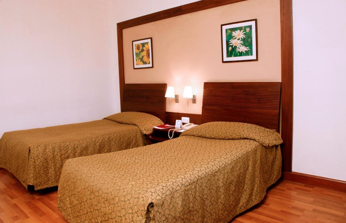 a hotel room with two beds in a room at The Retreat Hotel & Convention Centre in Mumbai