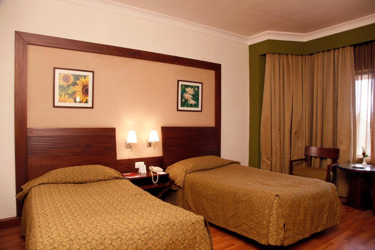 a hotel room with two beds and a window at The Retreat Hotel & Convention Centre in Mumbai