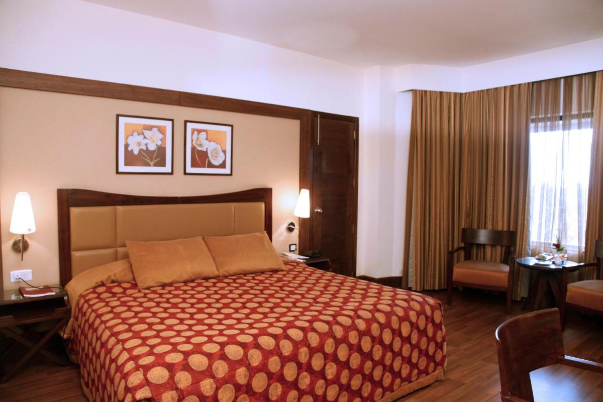 a hotel room with a bed and a window at The Retreat Hotel & Convention Centre in Mumbai