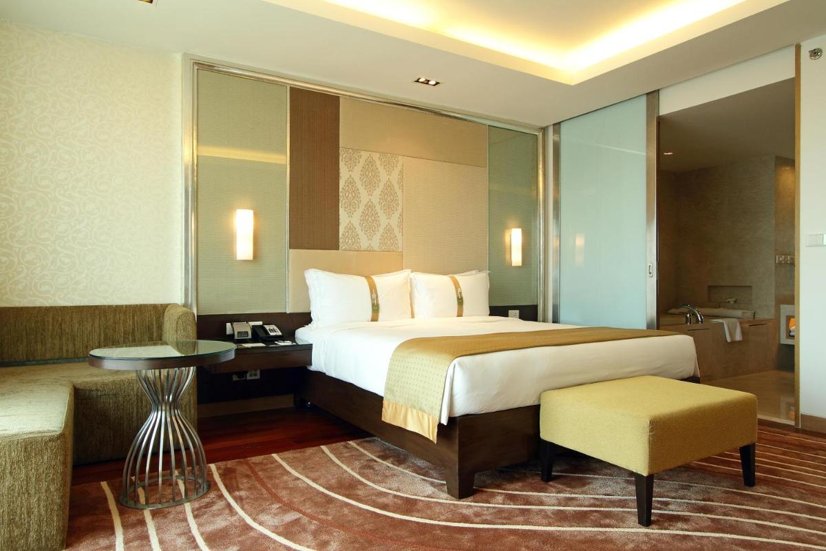 a hotel room with a large bed and a table at Holiday Inn Mumbai International Airport by IHG in Mumbai