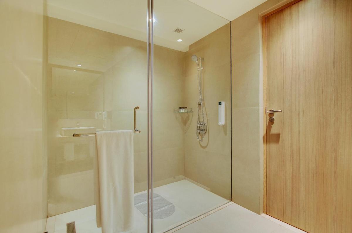 a bathroom with a shower with a glass door at Holiday Inn Bengaluru Racecourse by IHG in Bengaluru a bathroom with a shower with a glass door at Holiday Inn Bengaluru Racecourse by IHG in Bengaluru