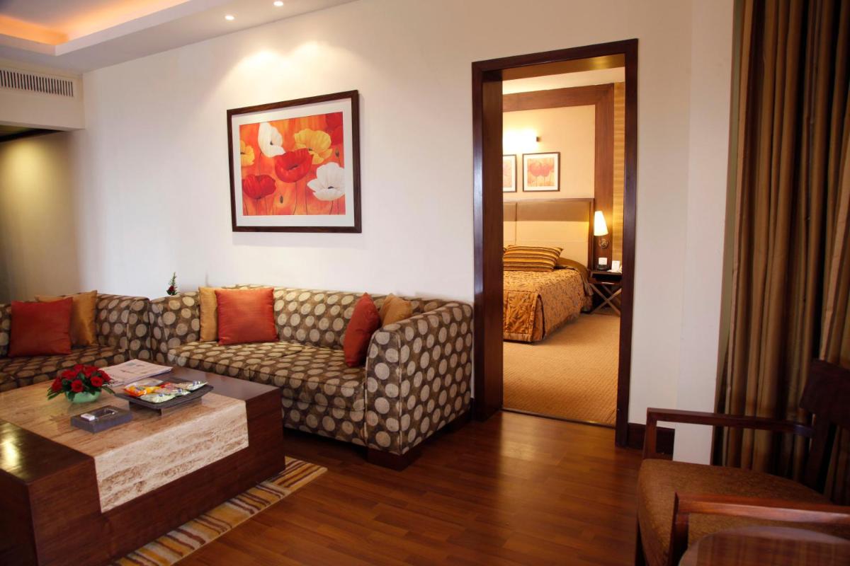 a living room with a couch and a table at The Retreat Hotel & Convention Centre in Mumbai