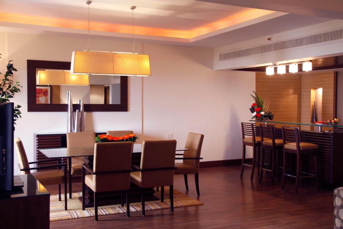 a dining room with a table and a bar at The Retreat Hotel & Convention Centre in Mumbai