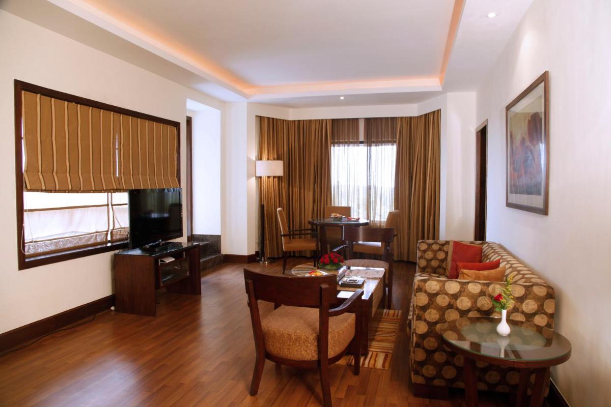 a living room with a couch and a table at The Retreat Hotel & Convention Centre in Mumbai