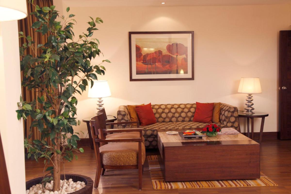 a living room with a couch and a table at The Retreat Hotel & Convention Centre in Mumbai