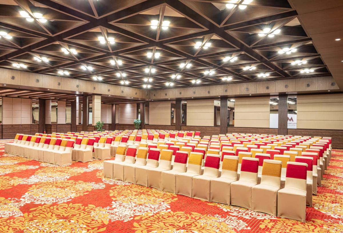 an empty auditorium with red and yellow chairs at Sterlings Mac Hotel in Bengaluru +78 photos