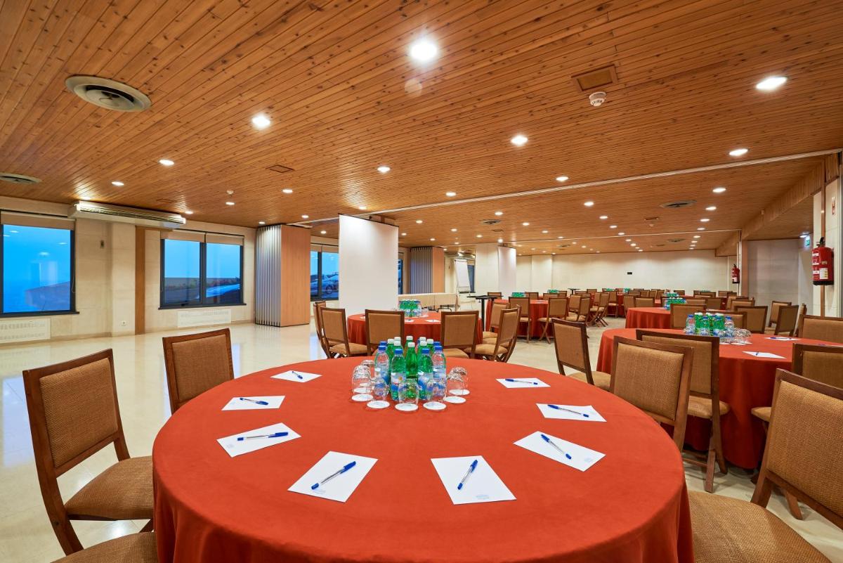 uma sala de conferências com uma mesa e cadeiras vermelhas em Hotel Golf Mar em Maceira mais 46 fotografias
