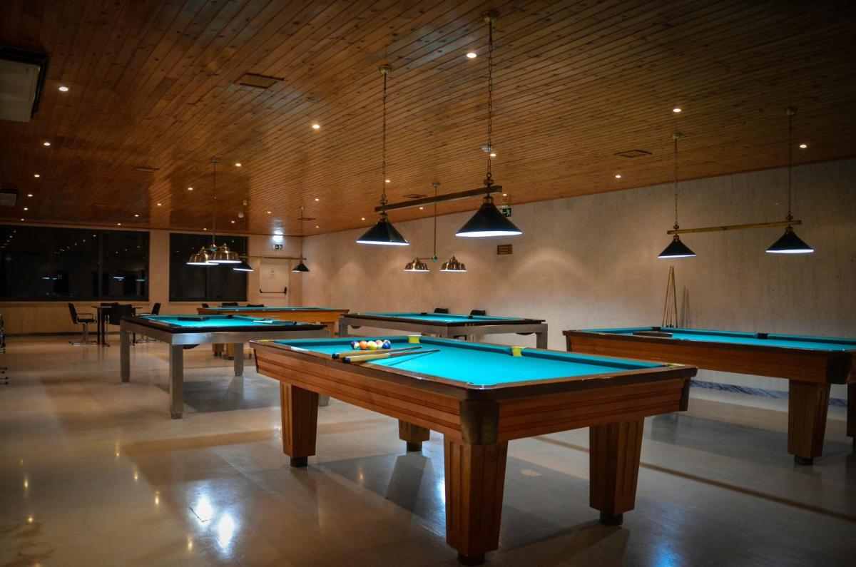 uma fileira de mesas de bilhar em uma sala grande em Hotel Golf Mar em Maceira