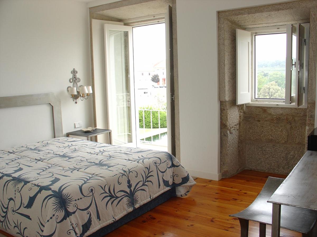um quarto com uma cama e uma janela grande em Hotel Convento dos Capuchos em Monção