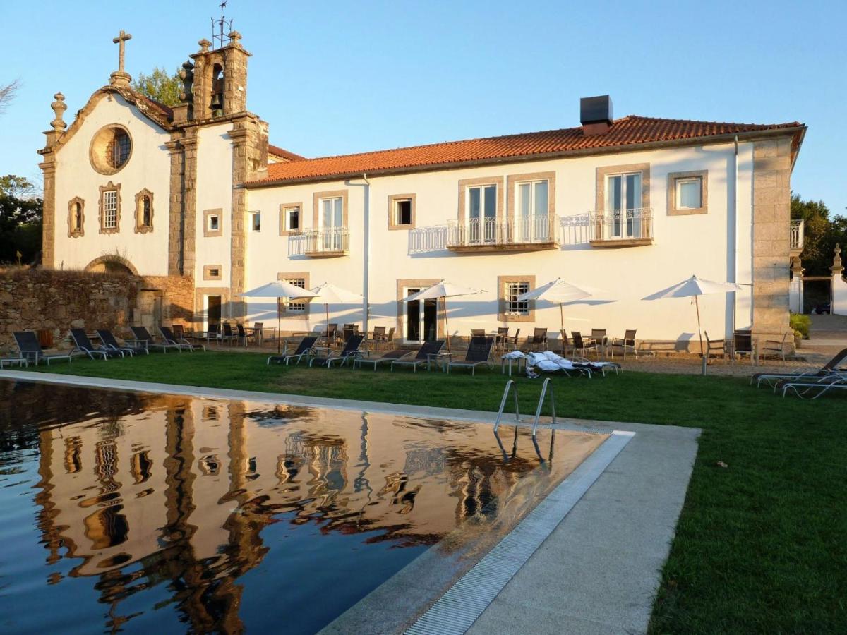 um grande edifício com um reflexo na água em Hotel Convento dos Capuchos em Monção