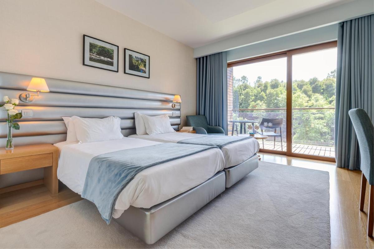 um quarto de hotel com cama e varanda em Hotel Rural Vale Do Rio em Oliveira de Azemeis mais 65 fotografias