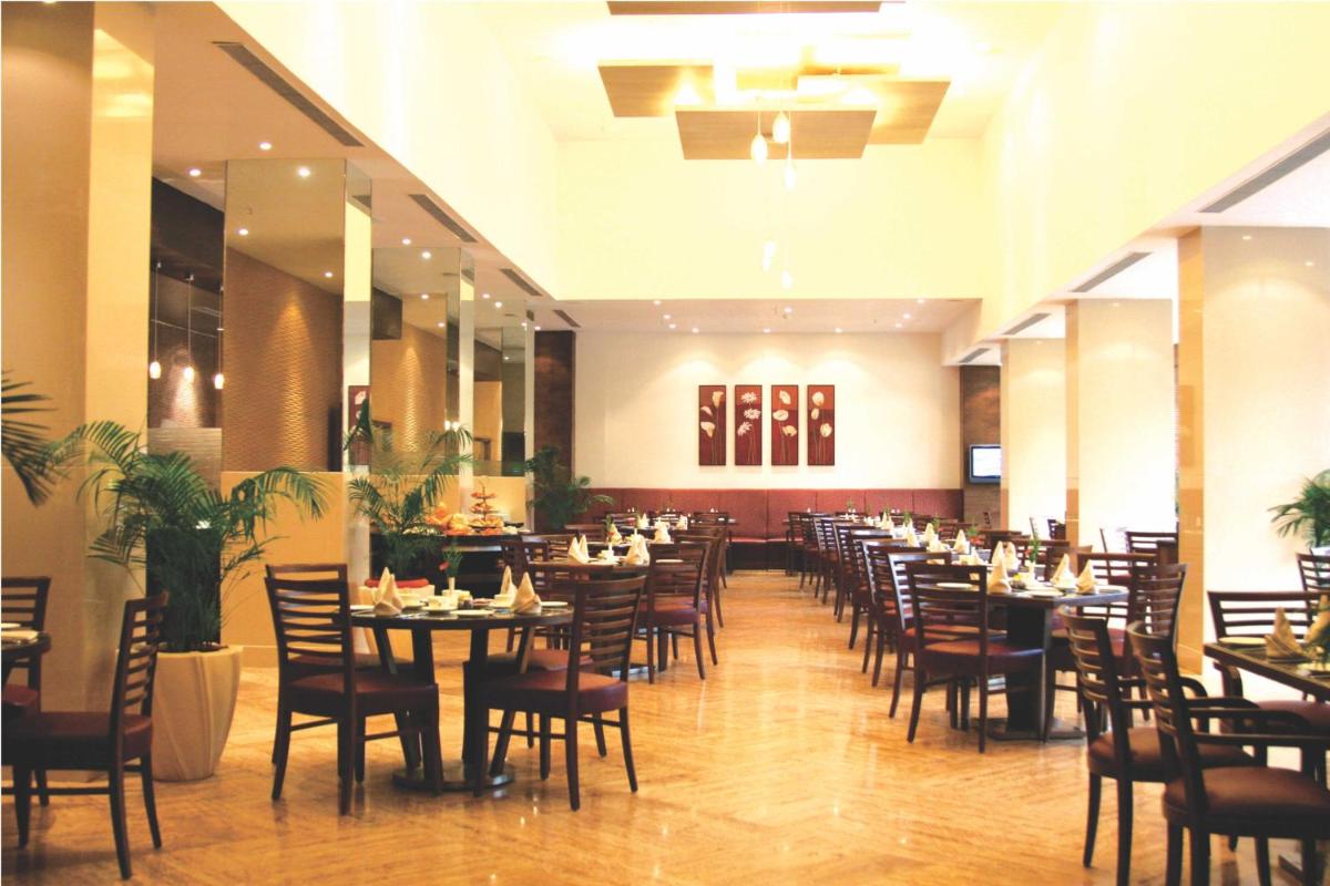 a dining room filled with tables and chairs at The Retreat Hotel & Convention Centre in Mumbai a dining room filled with tables and chairs at The Retreat Hotel & Convention Centre in Mumbai