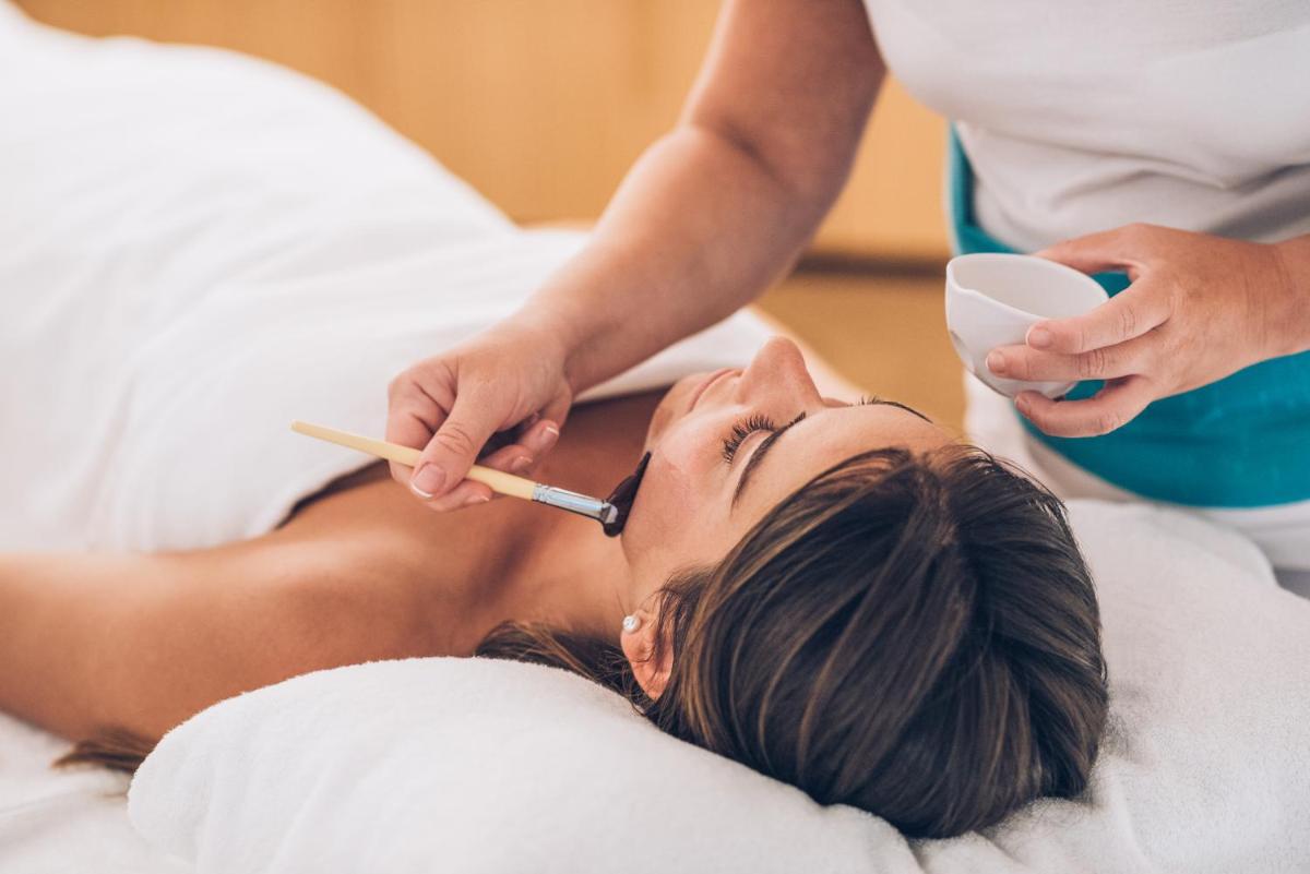 uma mulher deitada numa cama a lavar os dentes em Iberostar Selection Lisboa em Lisboa