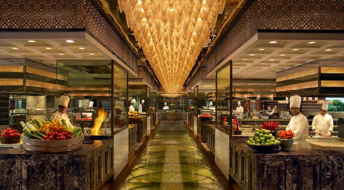 a kitchen with chefs preparing food in a restaurant at The Leela Ambience Gurugram Hotel & Residences - The Luxury Urban Sanctuary in Gurgaon