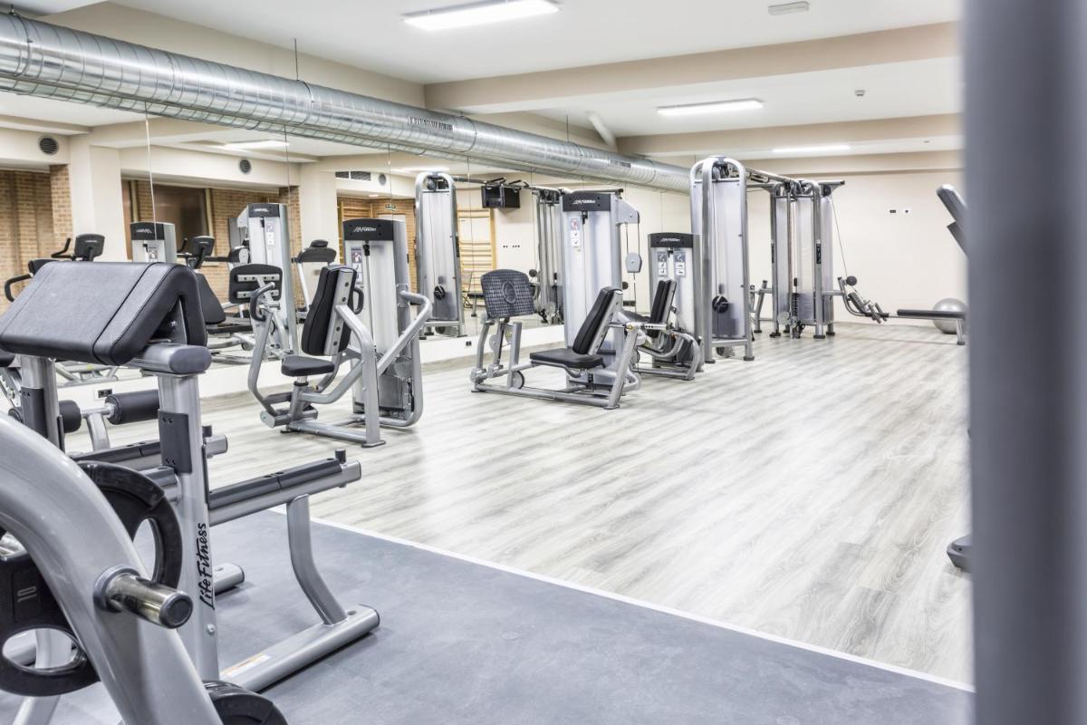un gimnasio con filas de cintas de correr y máquinas en Hotel Spa Rio Ucero, en El Burgo de Osma
