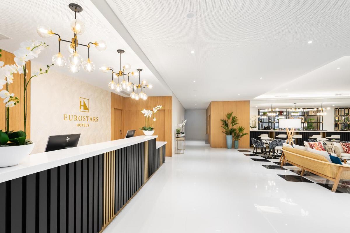 um átrio de um hotel com uma recepção e cadeiras em Eurostars Matosinhos em Matosinhos mais 48 fotografias