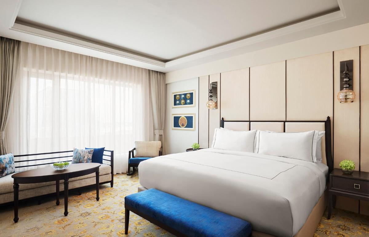 a hotel room with a large bed and a couch at Taj Tirupati in Tirupati +37 photos