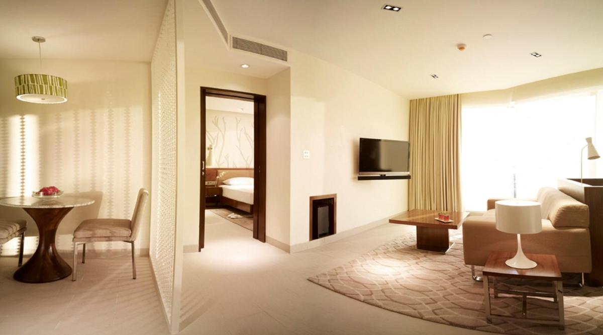 a hotel room with a bedroom and a living room at Taj Yeshwantpur Bengaluru in Bengaluru a hotel room with a bedroom and a living room at Taj Yeshwantpur Bengaluru in Bengaluru