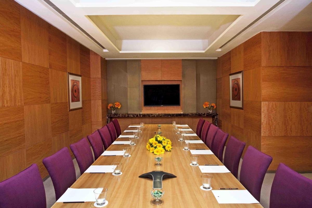 a conference room with a long table and purple chairs at Holiday Inn New Delhi Mayur Vihar Noida by IHG in New Delhi a conference room with a long table and purple chairs at Holiday Inn New Delhi Mayur Vihar Noida by IHG in New Delhi