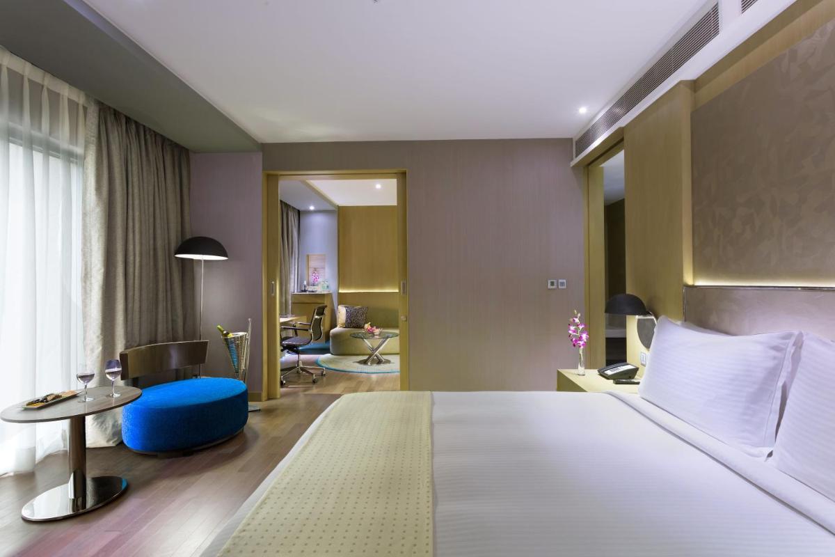 a hotel room with a large bed and a living room at Holiday Inn New Delhi Aerocity by IHG in New Delhi
