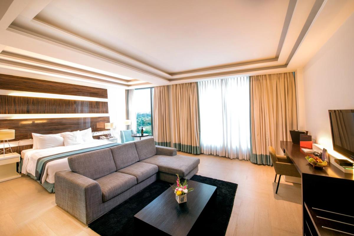 a hotel room with a bed and a couch at Welcomhotel by ITC Hotels, Dwarka, New Delhi in New Delhi a hotel room with a bed and a couch at Welcomhotel by ITC Hotels, Dwarka, New Delhi in New Delhi