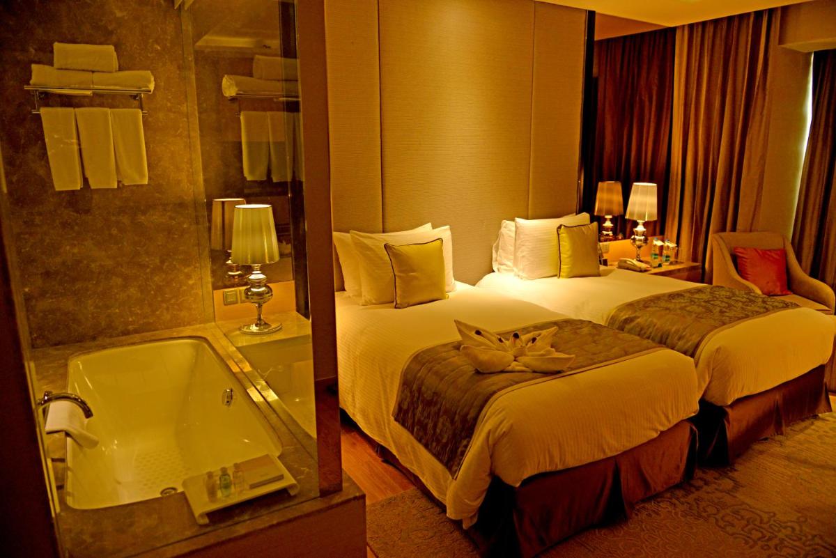 a hotel room with a bed and a bath tub at Radisson Blu Jaipur in Jaipur