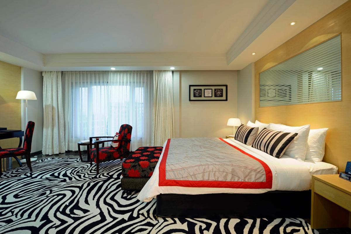 a hotel room with a bed with a zebra print carpet at Radisson Blu Hotel Ahmedabad in Ahmedabad