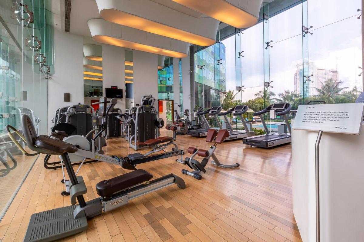 a gym with rows of treadmills and elliptical machines at Vivanta Bengaluru, Whitefield in Bengaluru