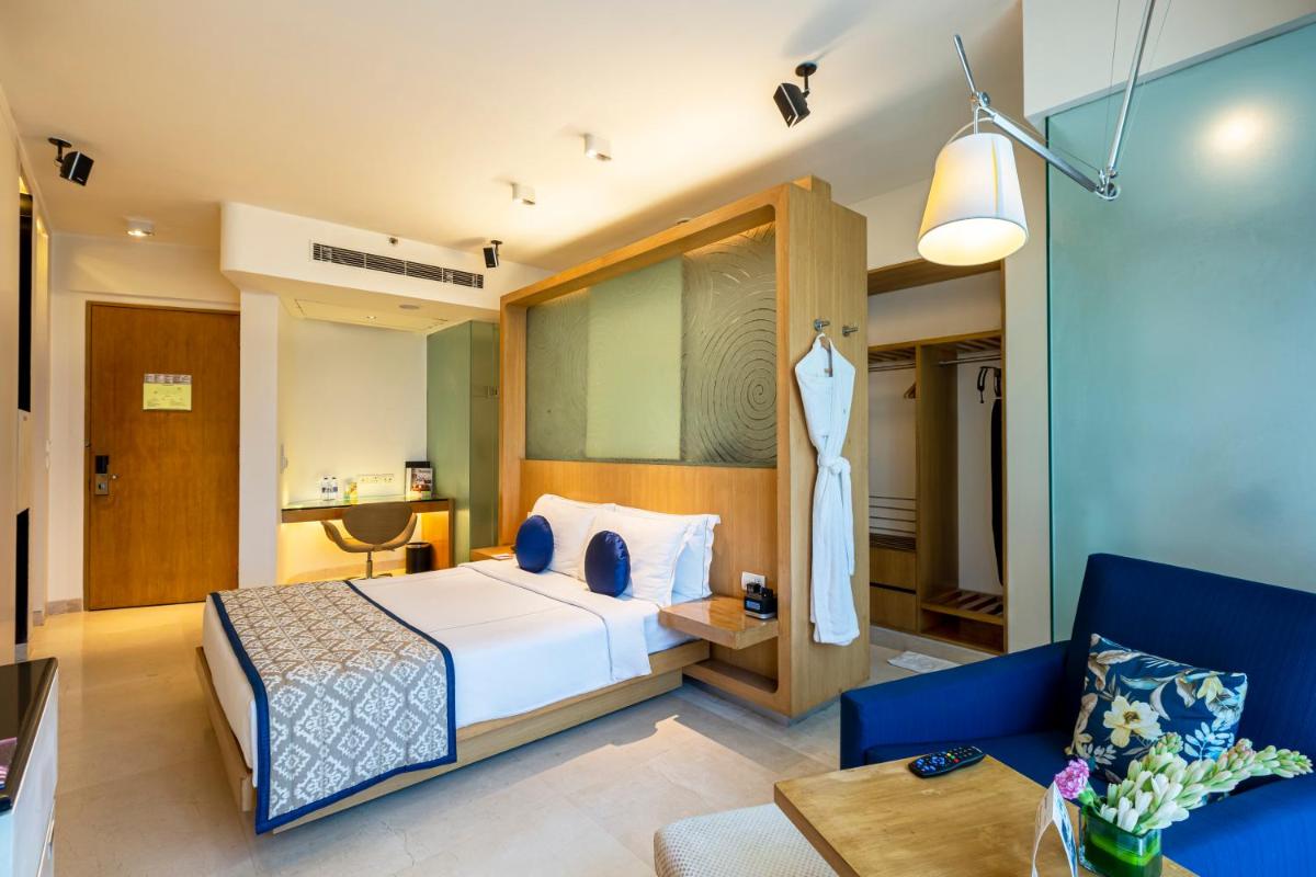 a hotel room with a bed and a couch at Vivanta Bengaluru, Whitefield in Bengaluru